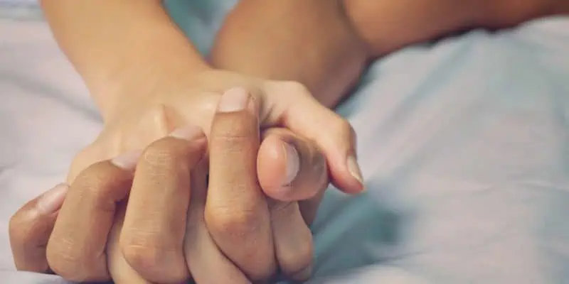 clasped hands of a man and woman