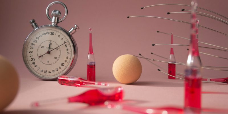 collection of a stopwatch, a foam ball, and several vials of red liquid